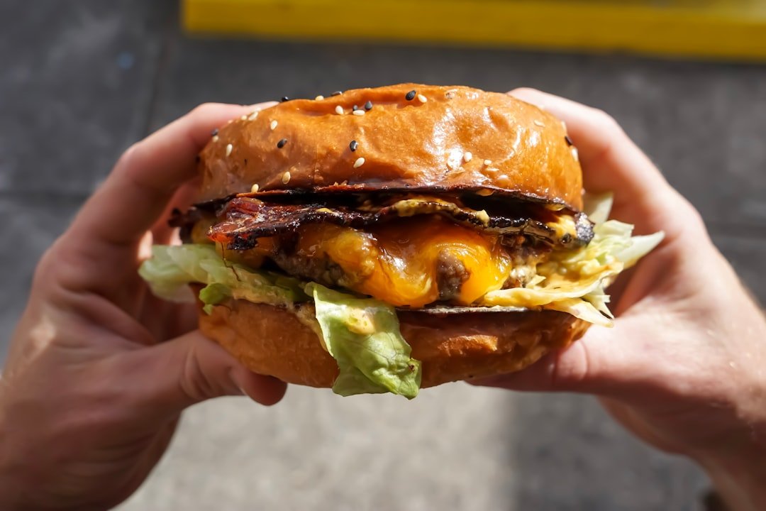 person holding cheese burger